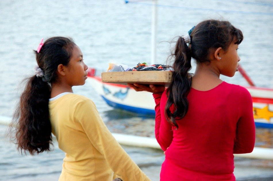 two child girls salling souvenirs at sea, bali