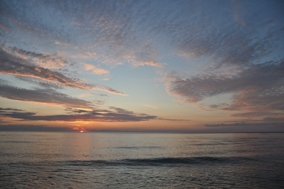 feather clouds over the sea at sunset