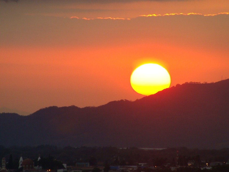huge bright sun is setting in the purple sky