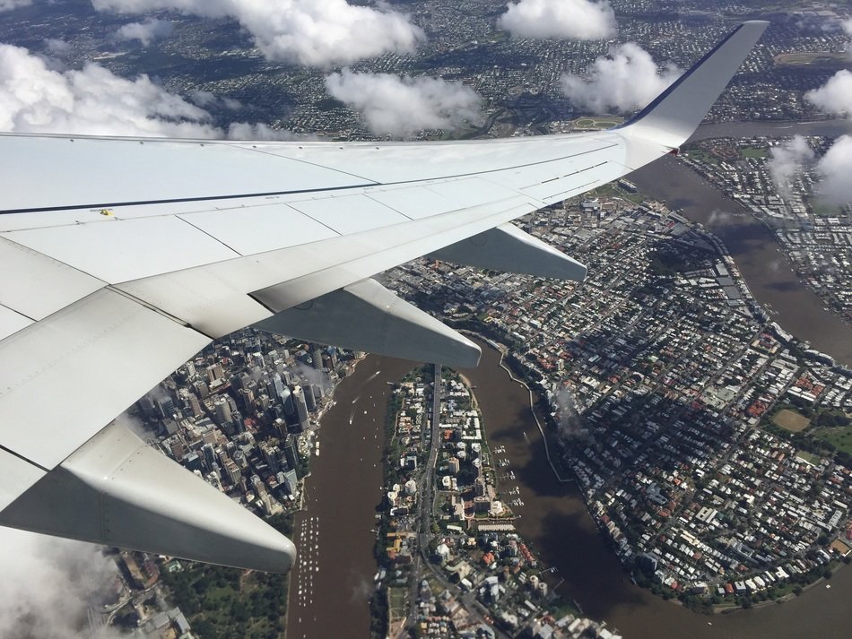 white wing of the plane over the city