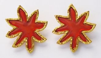 two gold earrings in the shape of maple leaves
