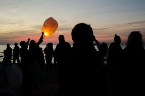 people launch chinese lanterns