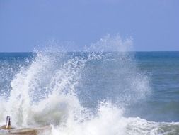 ocean splashes on the pier on a sunny day