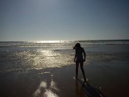 girl on the beach in the water at dusk