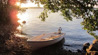 bright sunrise over a boat on a lake in finland