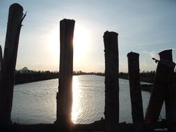 wooden pillars at sunset in thailand