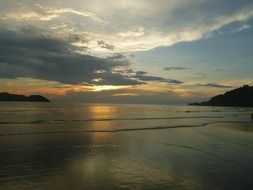 sunset in the clouds above the beach