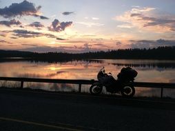 motorcycle near the lake at sunset
