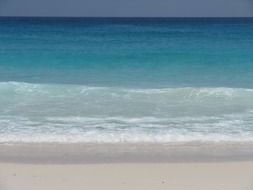 blue sea waves splashing on white beach