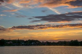 floating clouds at colorful sunset above the water