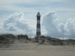 lighthouse on the beach against the background of clouds