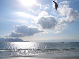 kitesurfing against the backdrop of the bright sun behind the clouds