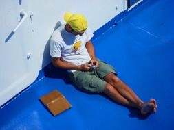 man sitting on the blue deck