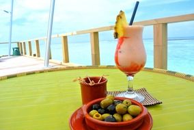 cocktail and olives in a bowl on the table