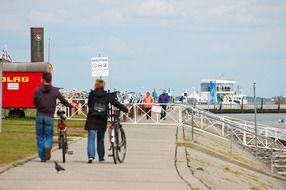 people walking by path at north sea, germany, wilhelmshaven
