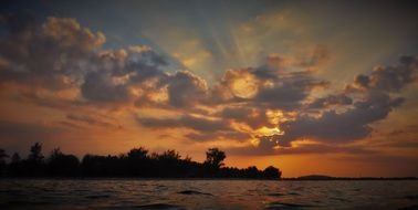 the sun behind the clouds at dusk