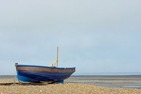 blue wooden fishing boat on the shore