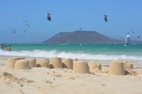 kites in sky above sand beach, spain, isla de lobos