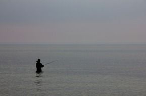 Angler with the fishing rod in the ocean