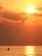 distant view of kayak in bright sunset