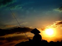 silhouette of a fisherman on the beach at sunset in Vietnam