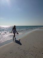 girl walking along the beach in sunshine