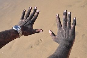black hands on sand background