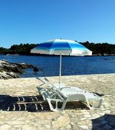 beach umbrella near a deck chair on the beach