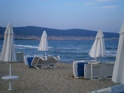 umbrellas near deck chairs on the beach of bulgaria