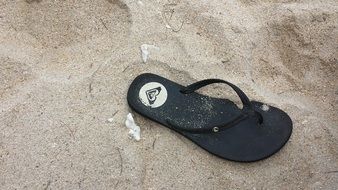 black beach sandal on sand