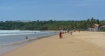 people resting on sand beach, india, goa, bogmalo