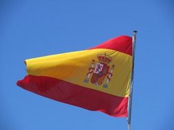 flag of spain on wind in blue sky