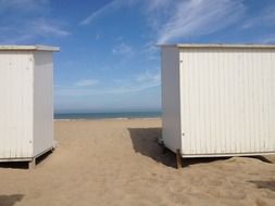 white beach cabins near sea