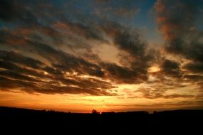 the sun behind dark clouds in the evening
