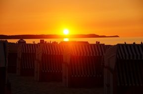 row of beach canopies at sunset