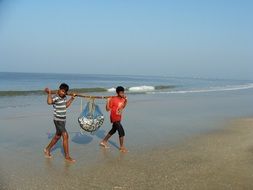 fishermen with their catch are on the sea beach of Goa