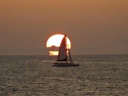 silhouette of a sailing boat on the background of an sunset