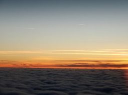 traces of aircraft against the backdrop of an orange sunset