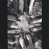 black and white photo of people's feet in the sand