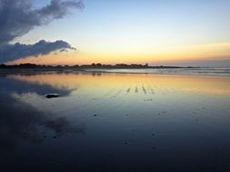 beautiful sunset mirroring on beach at sea, france, brittany