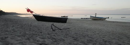 boats on the sandy shore of the Baltic Sea at dusk