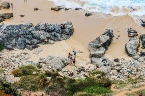 aerial view of big rocks on a sand beach