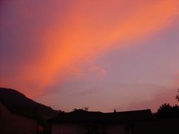 red-orange sunset sky over the hill