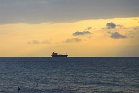 cargo ship on the horizon in the sunset