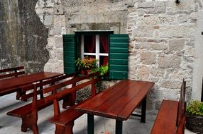 tables with benches near the stone wall