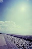 sunny sky on stone sea beach scene