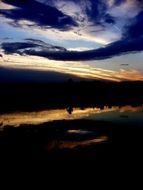 Dark blue clouds at sunset over the lake