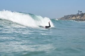 a surfer dives into a wave