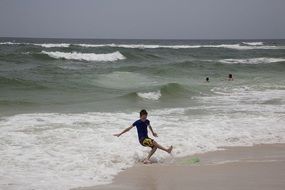 child plays with waves on the beach