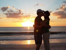 a loving couple is kissing on the beach